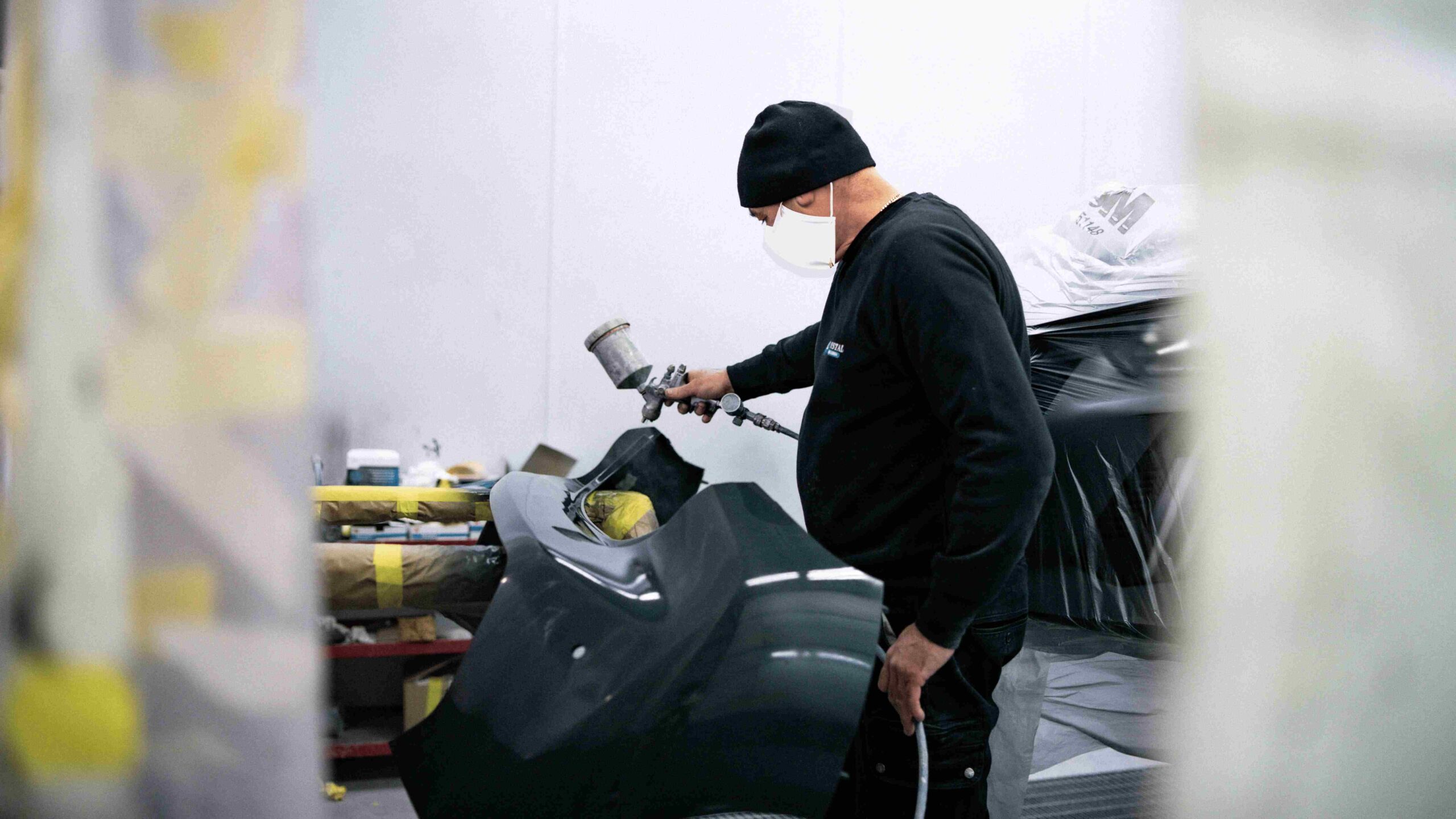 Un uomo che vernicia un auto.